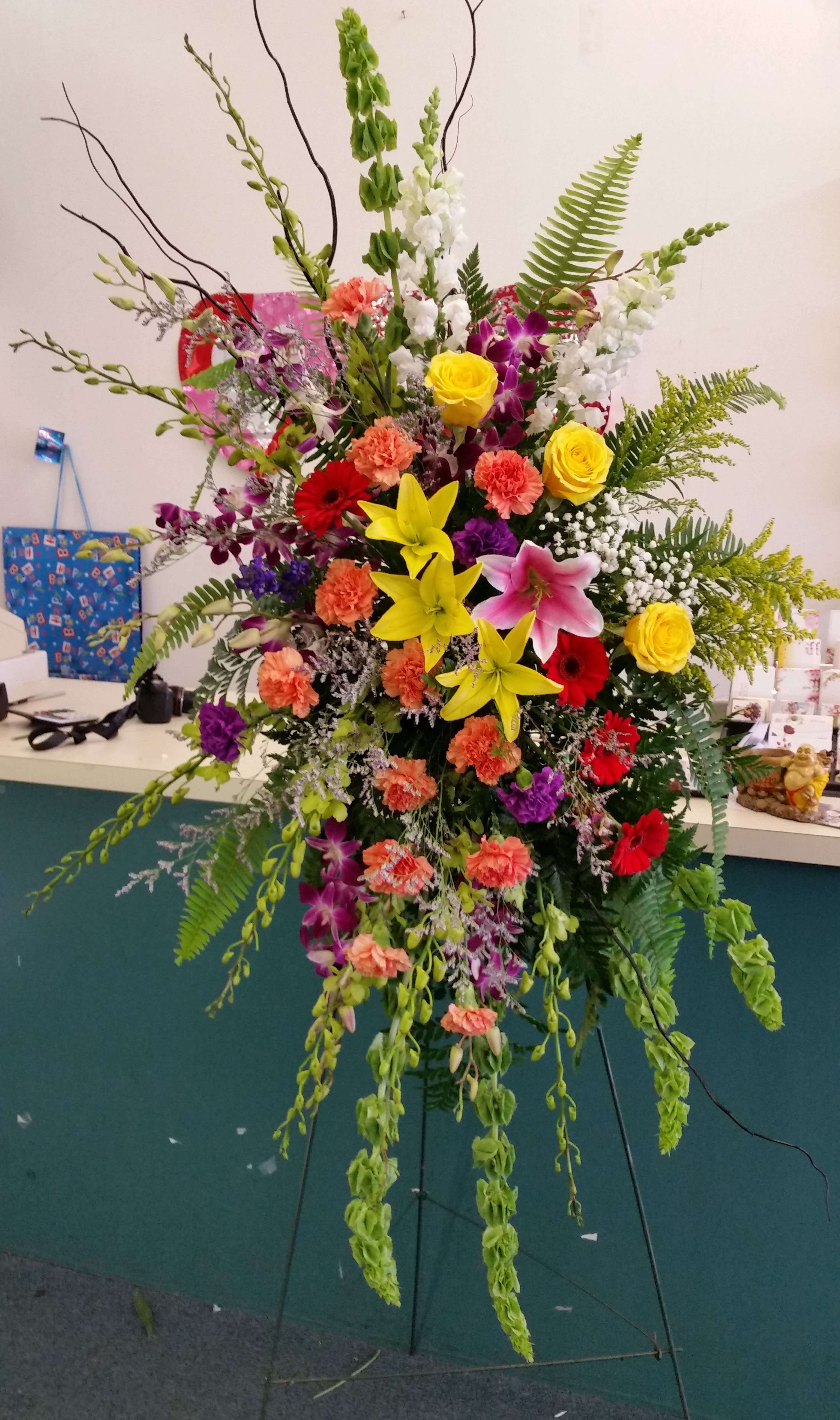 Tall mixed flower standing spray with lilies, roses, and orchids