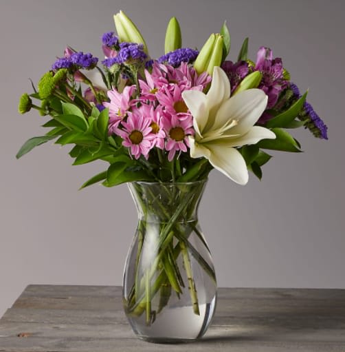 Lavender Fields Mixed Flower Bouquet - Picked fresh from the farm to offer your special recipient a bouquet blooming with a sweet appeal, the Lavender Fields Mixed Flower Bouquet is set to send your warmest greetings to friends and family near and far. Hand gathered in select floral farms and boasting a soft array of enchanting colors, including lavender, purple, and white, this gorgeous flower arrangement has been picked fresh for you to help you celebrate a birthday, or express your thank you or get well wishes.  This bouquet includes the following: white Asiatic Lilies, Purple Super Select Alstroemeria, Purple Button Pom, Lavender Daisy Pom, Purple Sinuata Statice, and an assortment of lush greens.  Approximately 13"H x 12"W