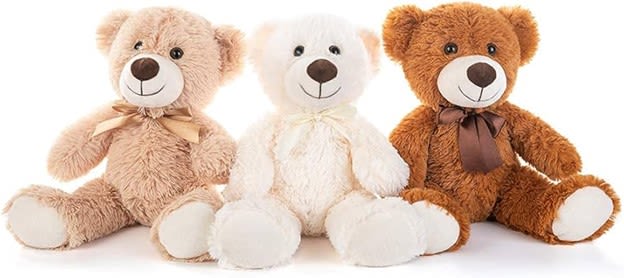 Three plush teddy bears in beige, white, and brown with bows