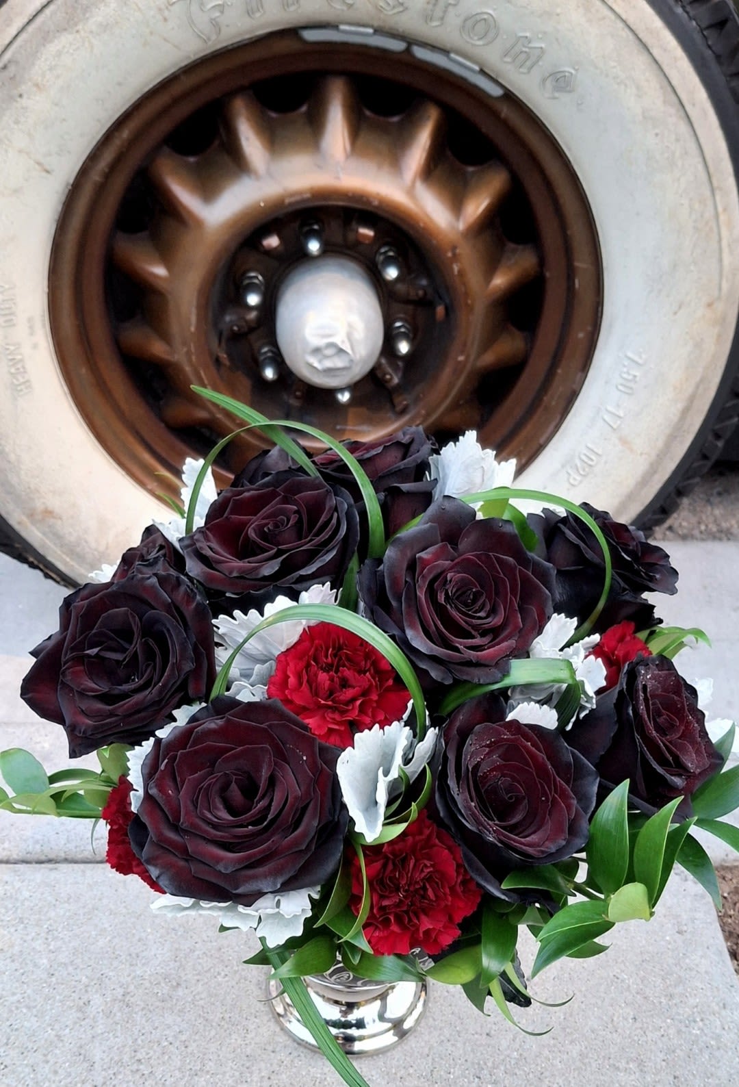 Bouquet of dark red roses and red carnations in a silver vase