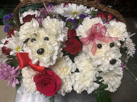 Two teddy bear floral arrangements with red roses and white flowers