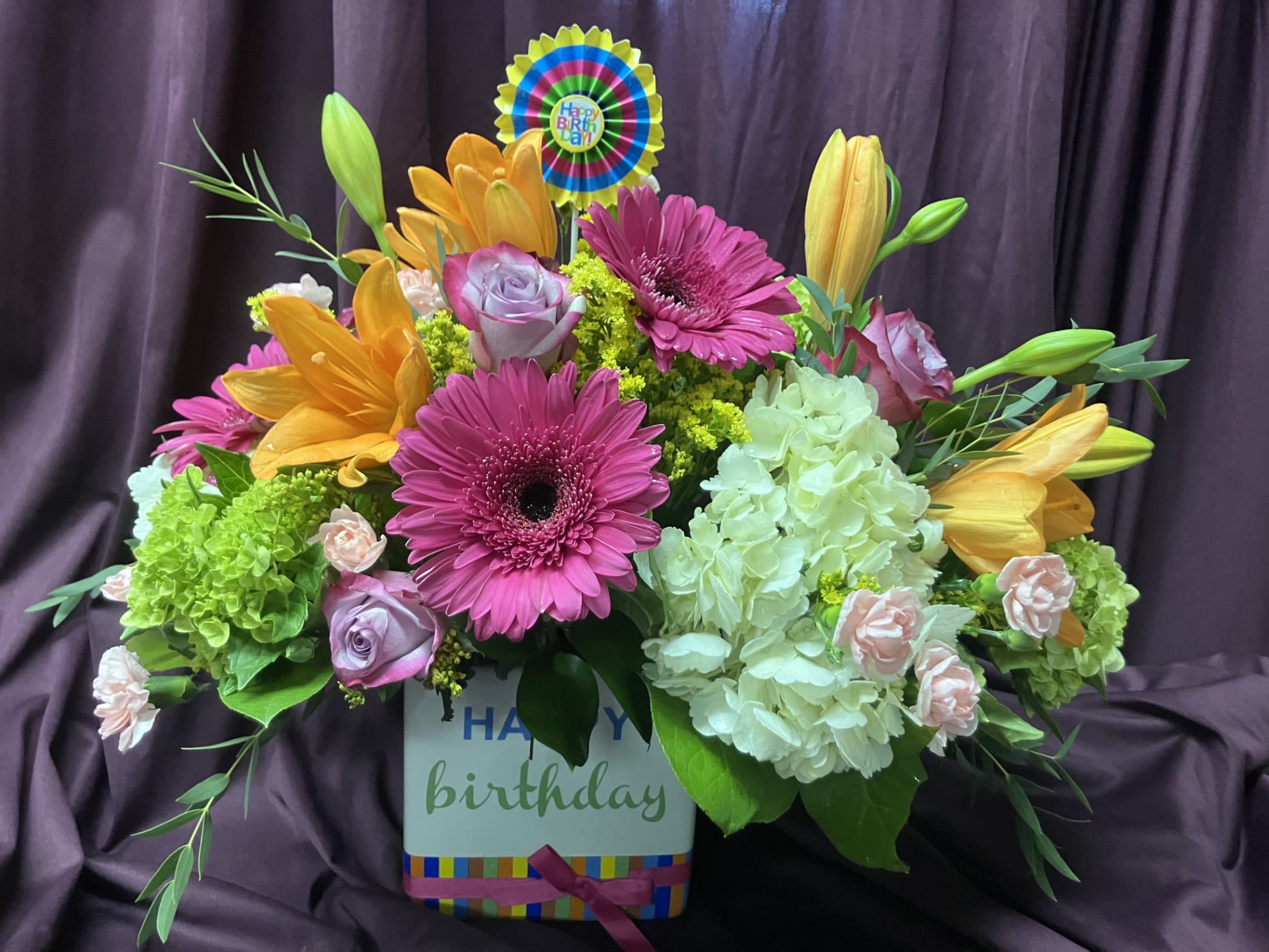 Colorful birthday flower arrangement in a box with gerberas, lilies, roses, and hydrangeas