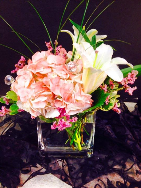 Pink hydrangeas and white lilies in a clear glass vase