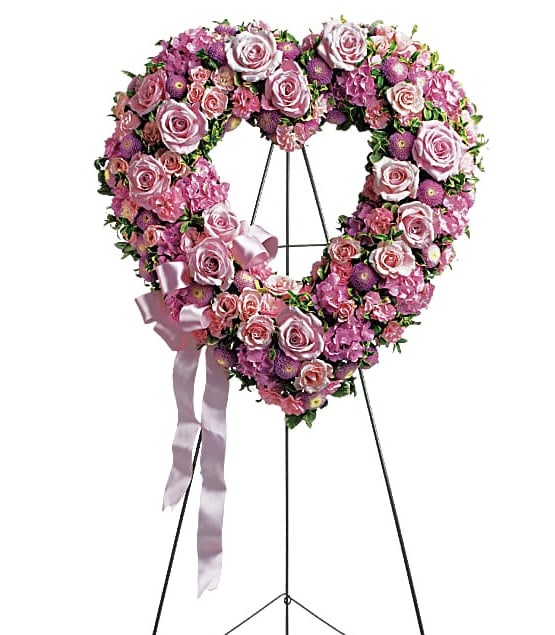 Heart-shaped pink rose wreath on a stand with a satin ribbon