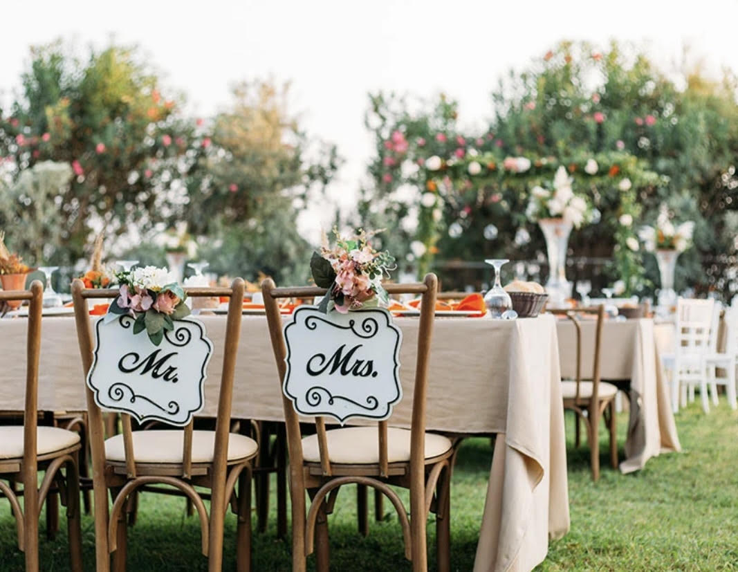 Wedding reception table with floral chair signs reading Mr. and Mrs.
