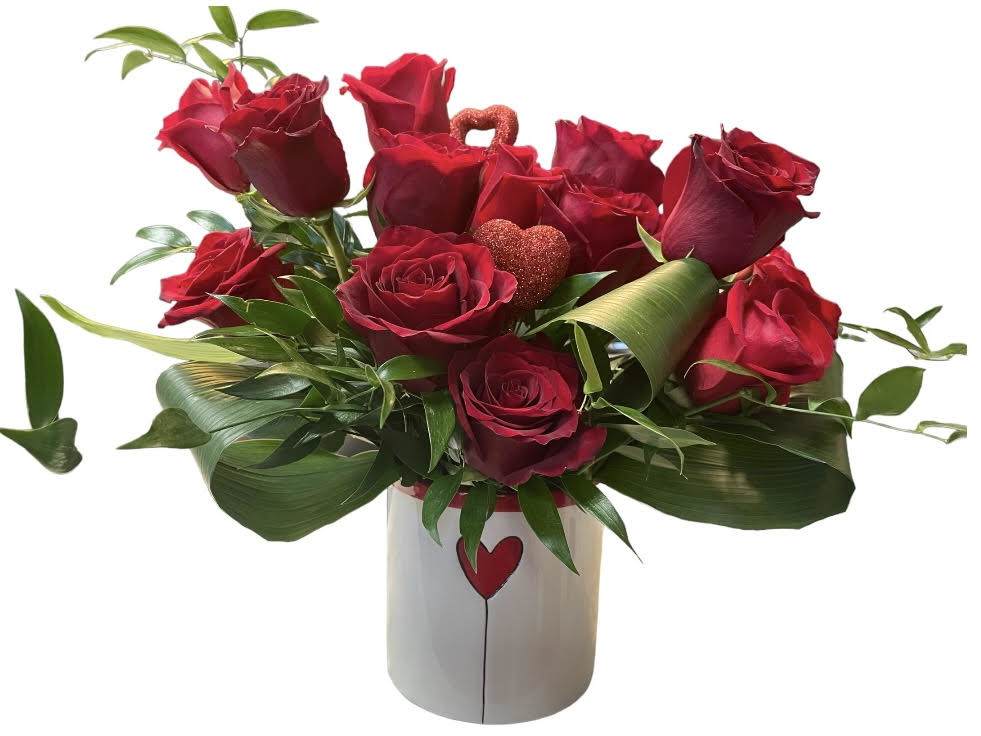 Red roses arranged in a white vase with a heart design