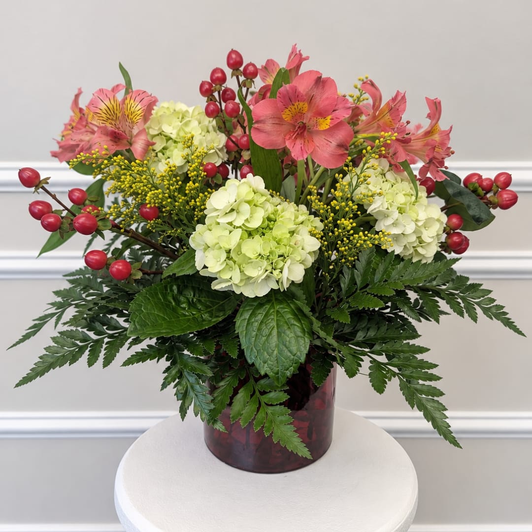 Pink alstroemeria and pale hydrangeas in a red vase