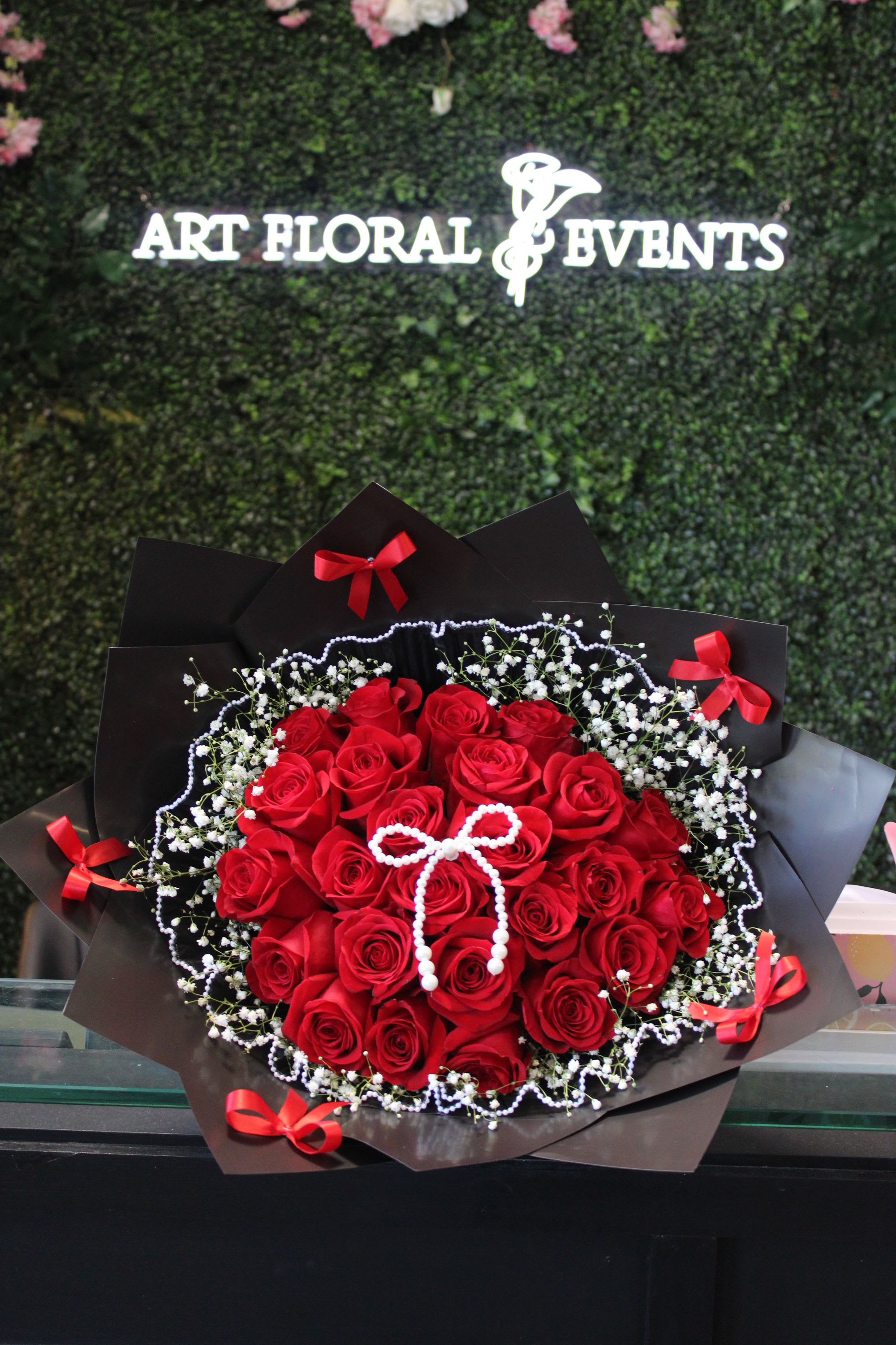 Bouquet of red roses with baby's breath and black wrapping