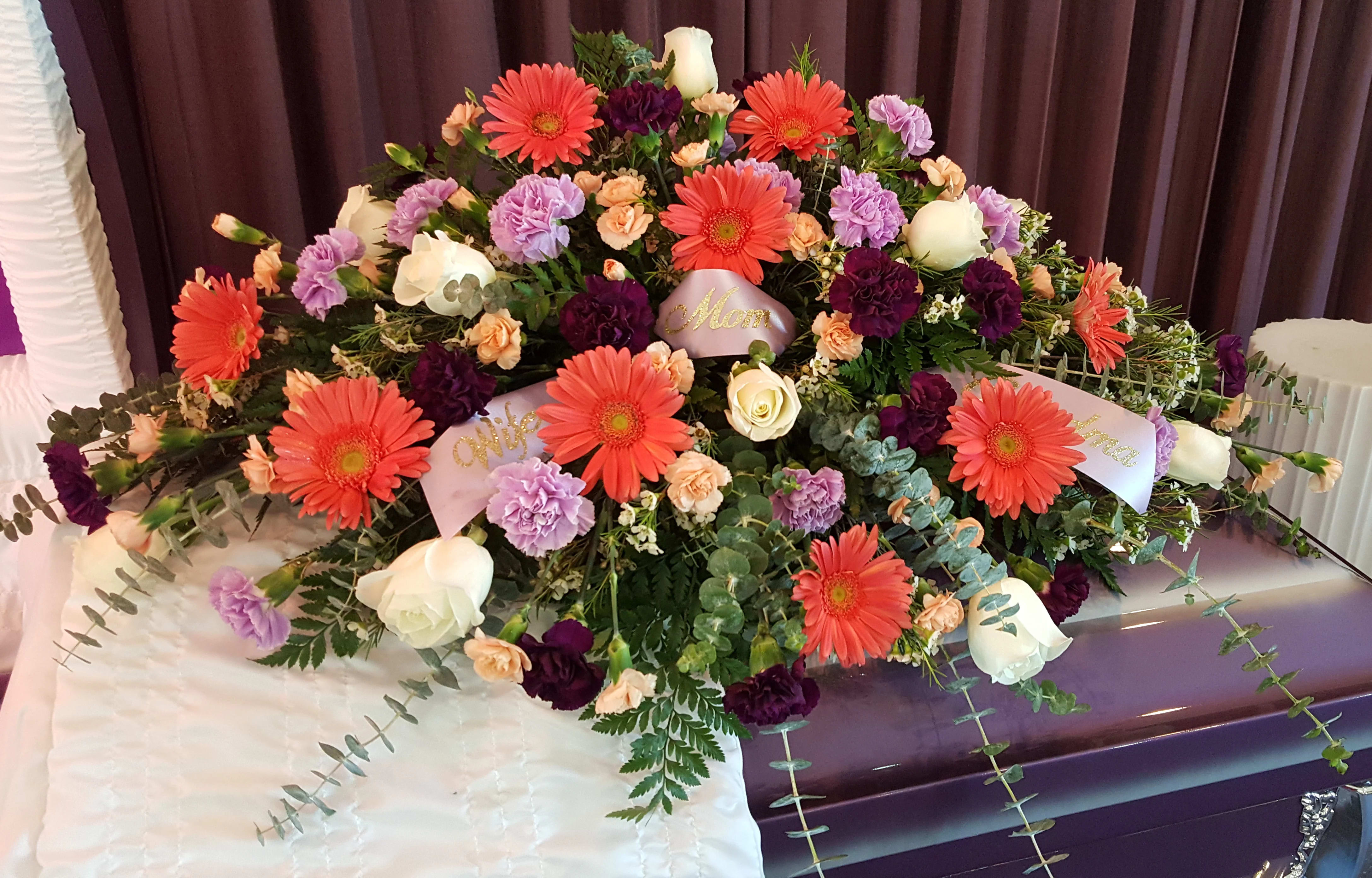 Large casket spray with gerbera daisies, roses, and carnations