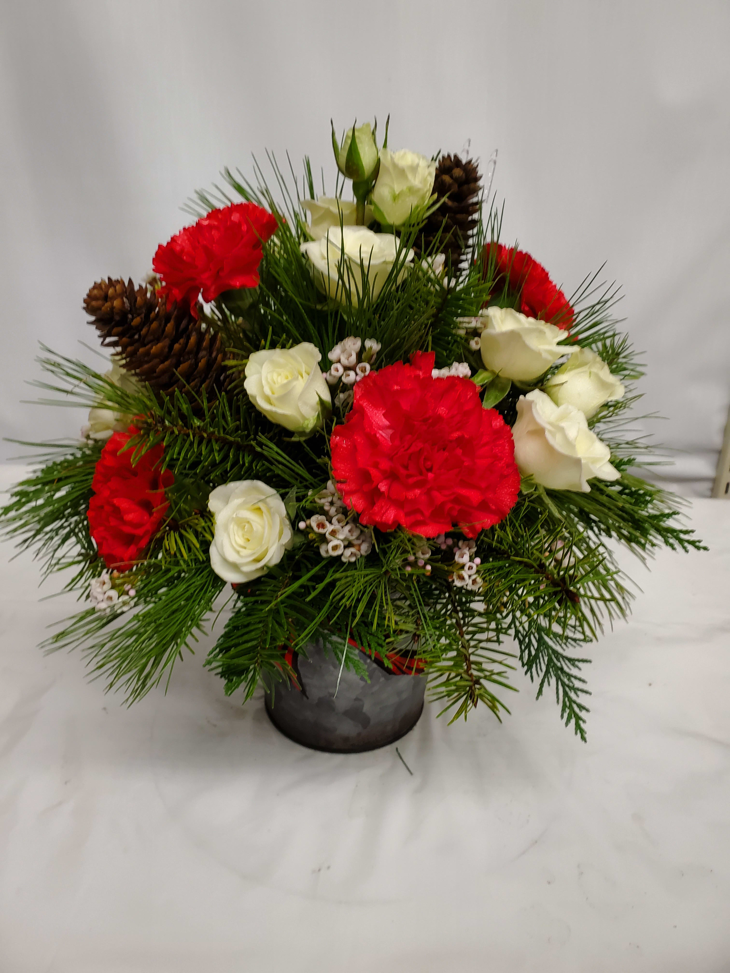 Red and white roses with carnations in a small vase