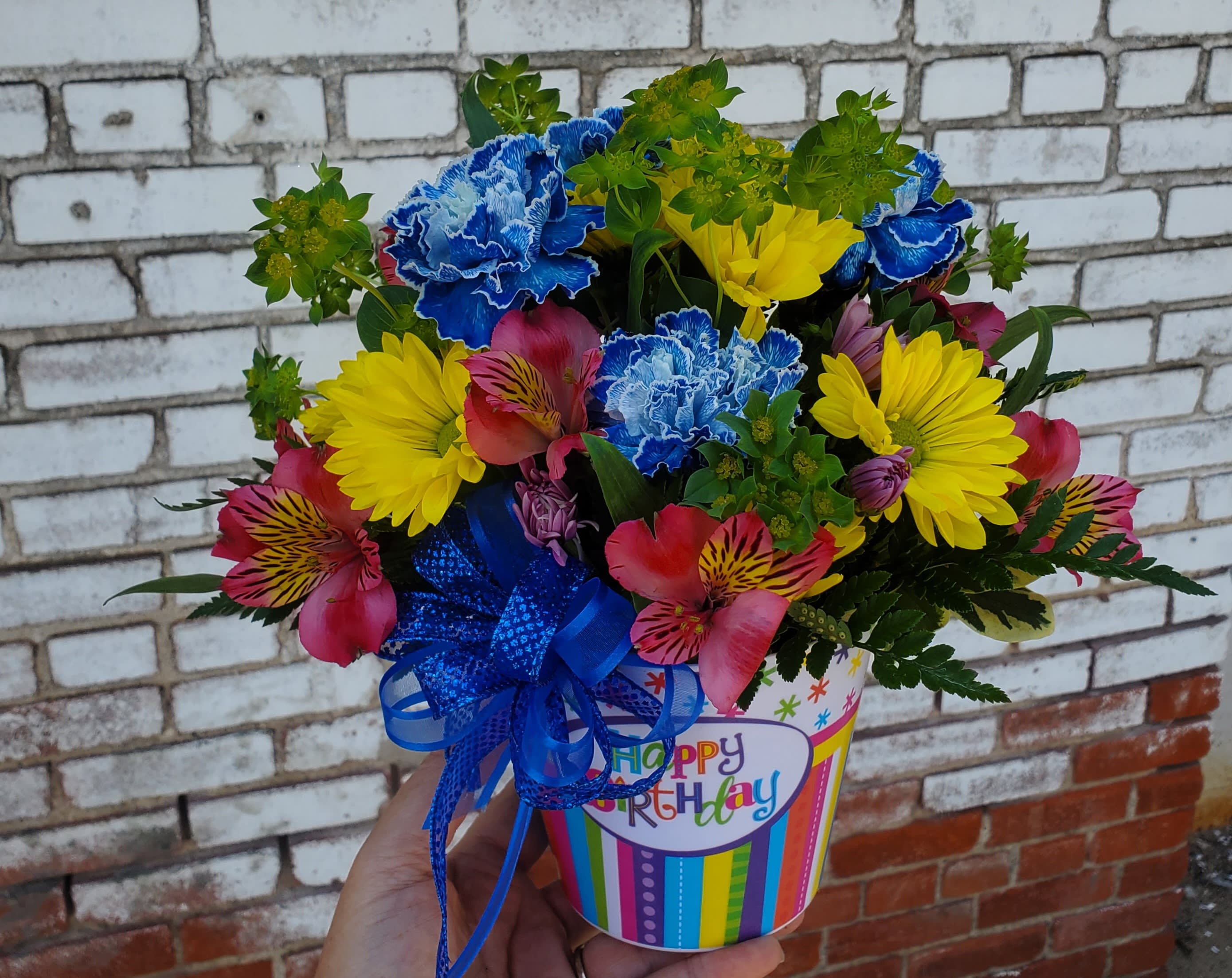 Colorful bouquet in a birthday gift container with a blue ribbon