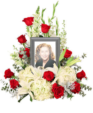 Memorial floral frame with red roses, white lilies, and a portrait