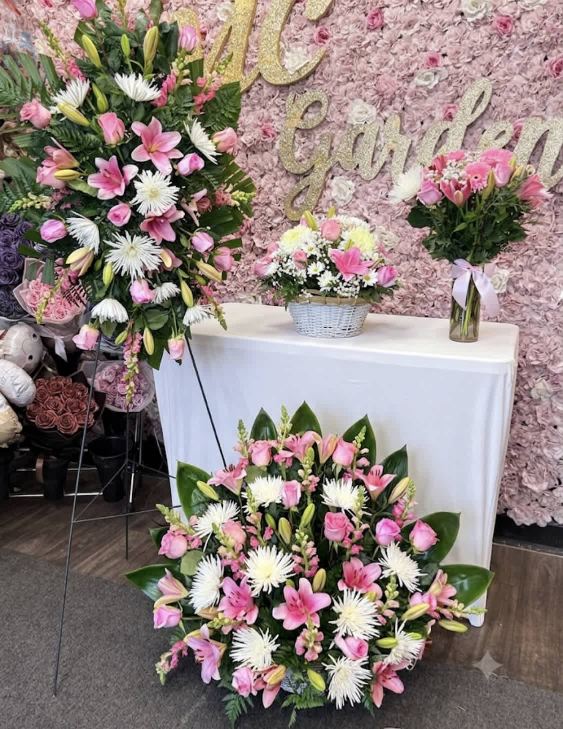 Pink and white floral arrangements with lilies and roses at a decorated display