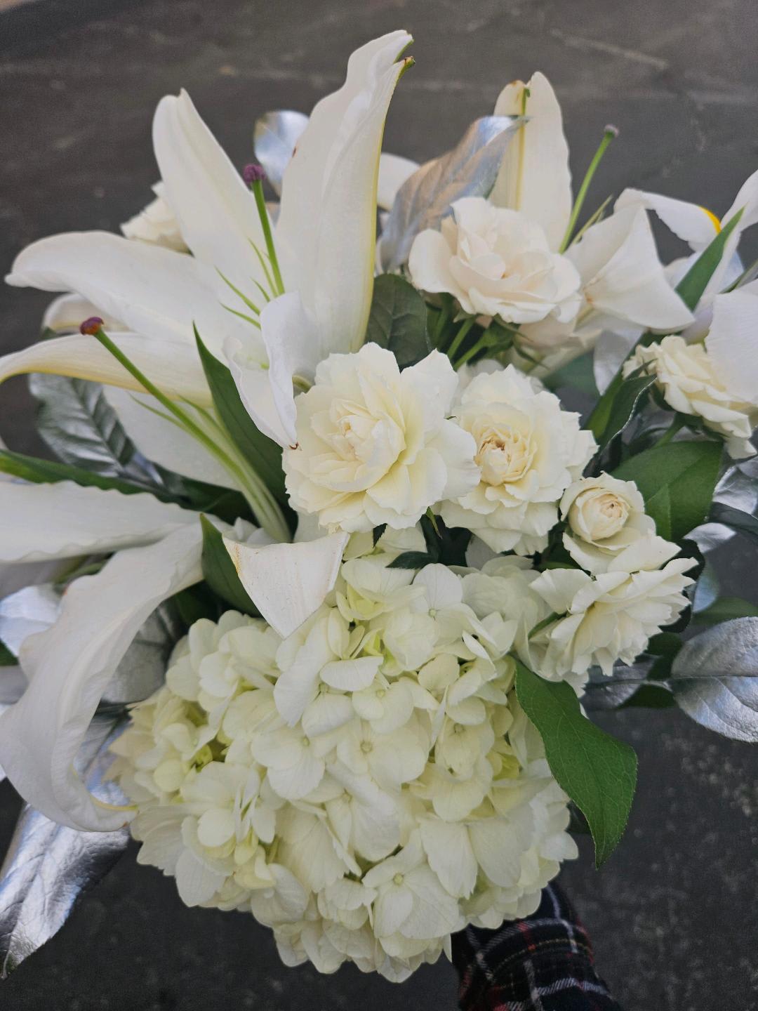 White floral bouquet with lilies, roses, and hydrangea