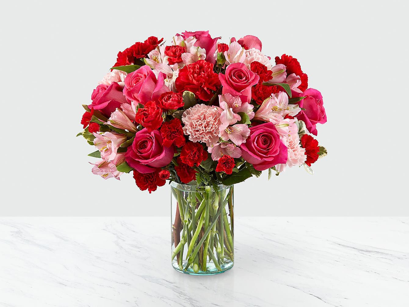 Pink and red mixed flower bouquet in a clear glass vase