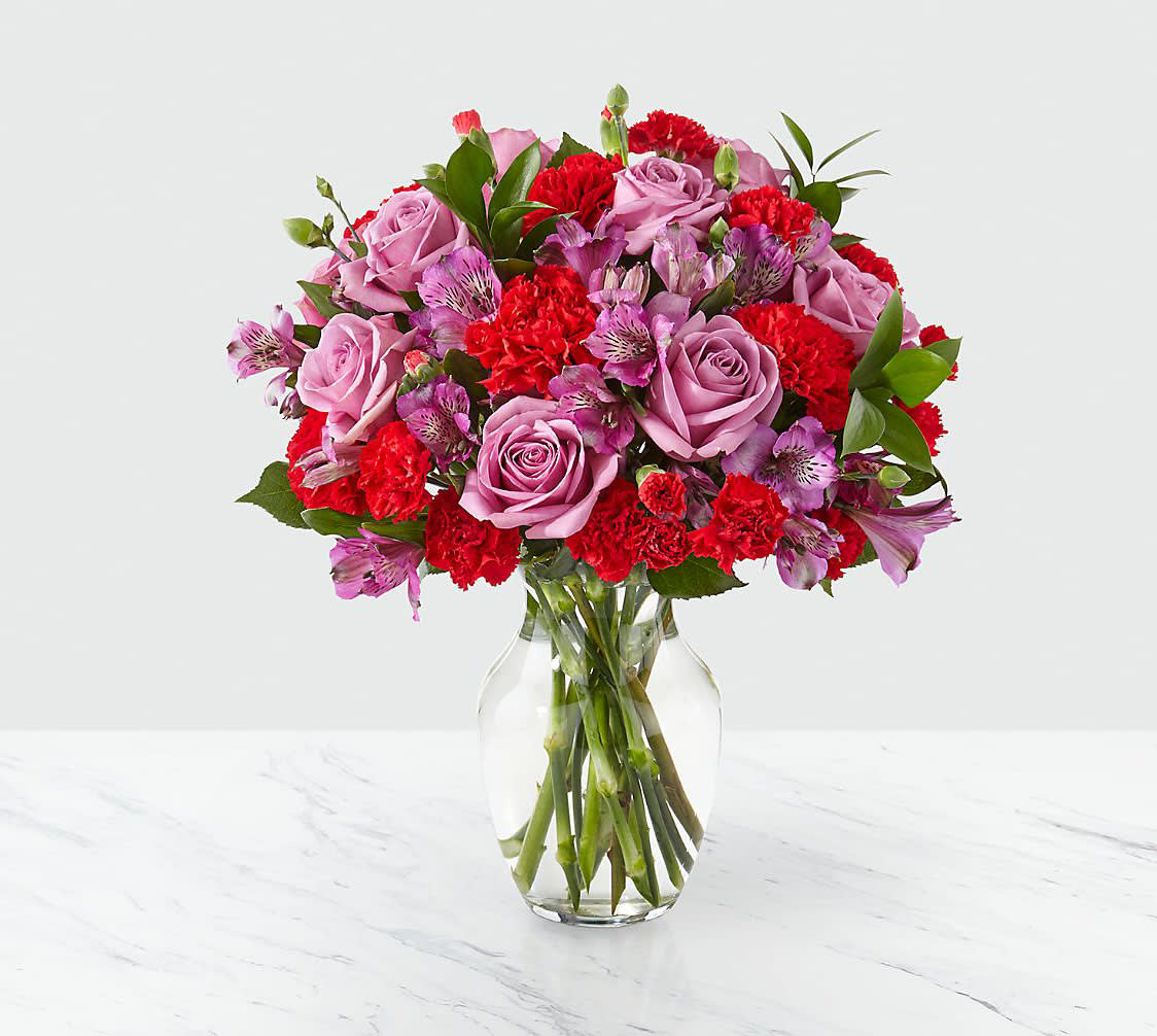 Pink roses and red carnations in a clear glass vase
