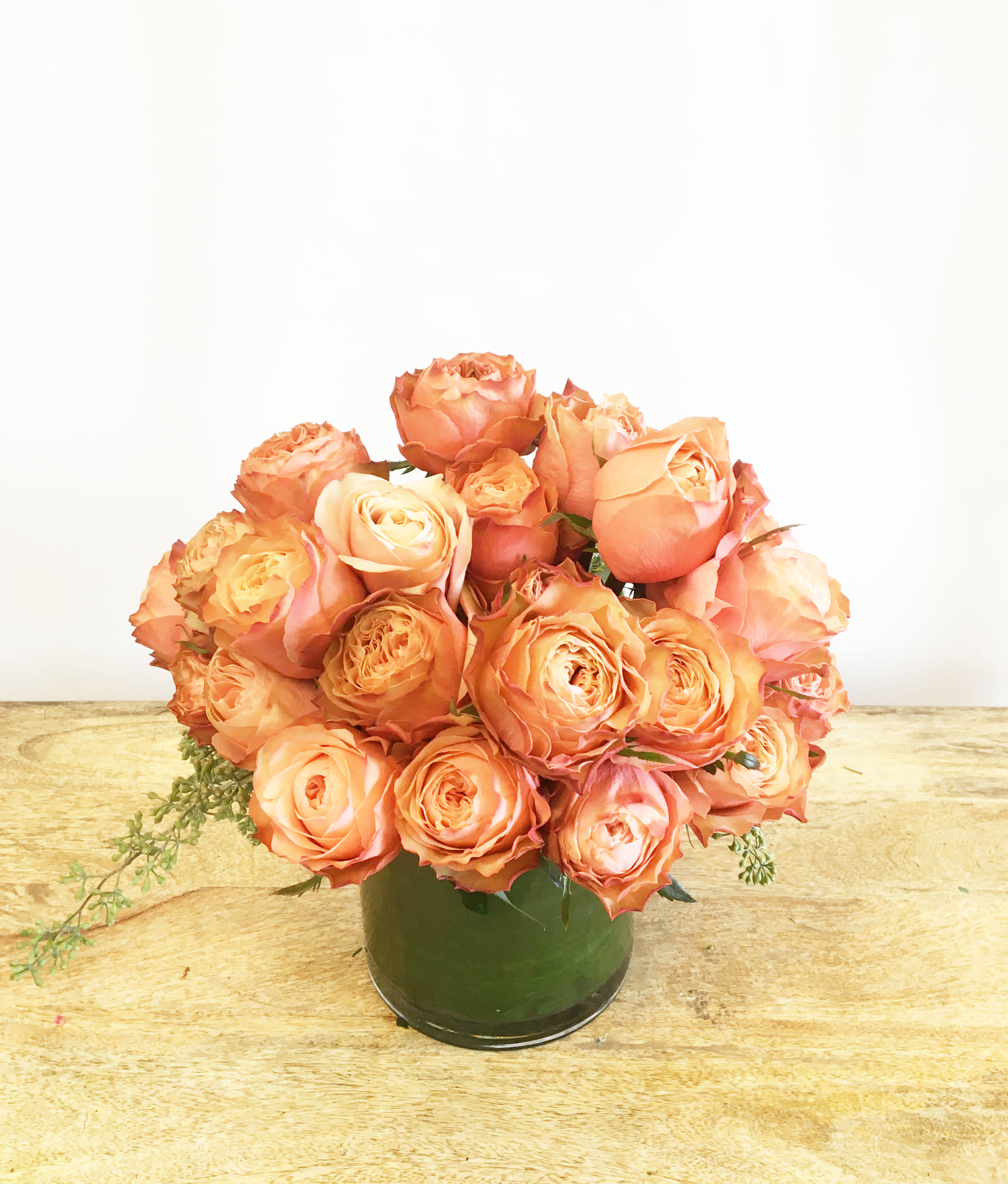 Peach roses arranged in a green vase