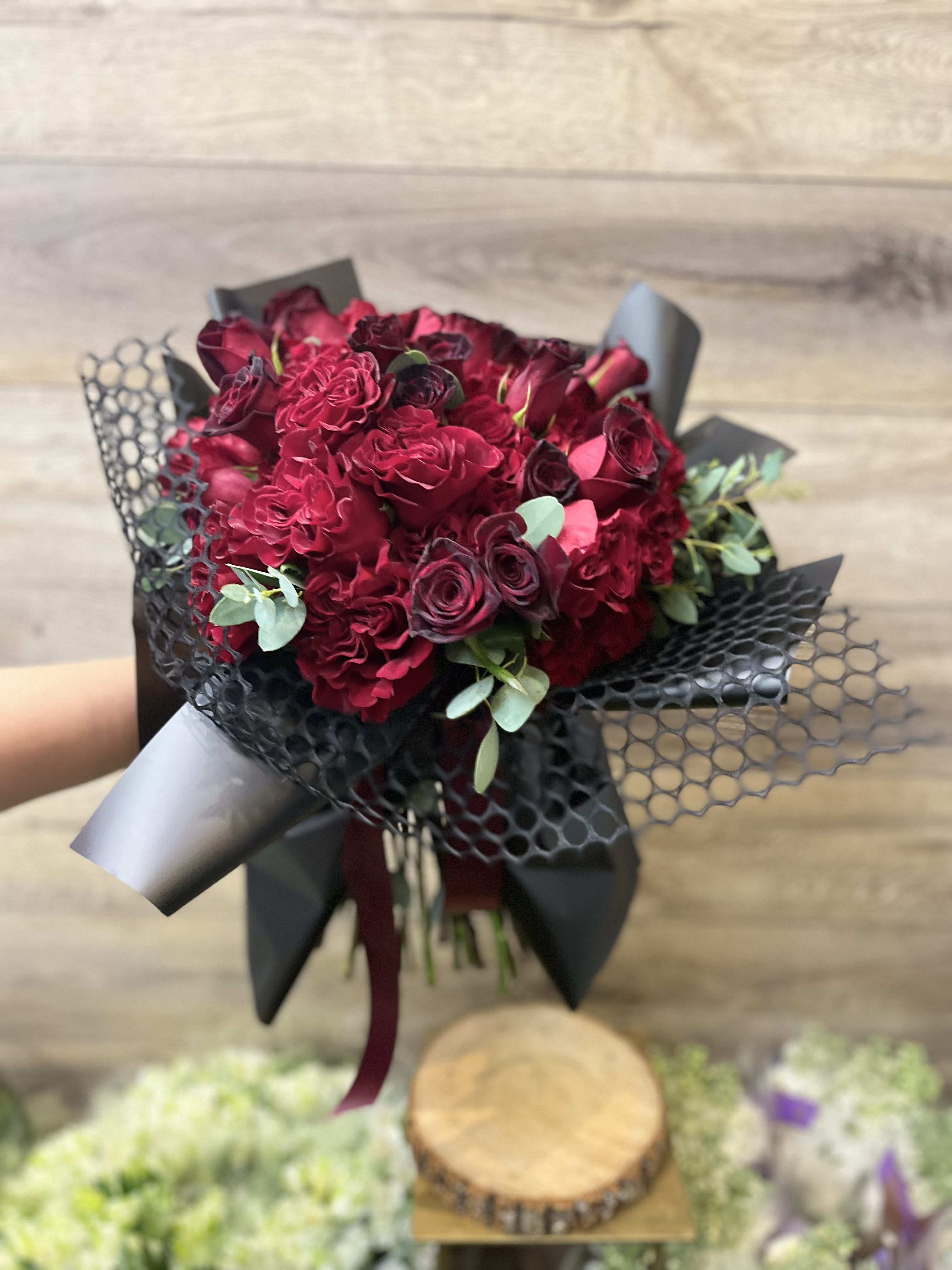 Bouquet of deep red roses wrapped in black paper