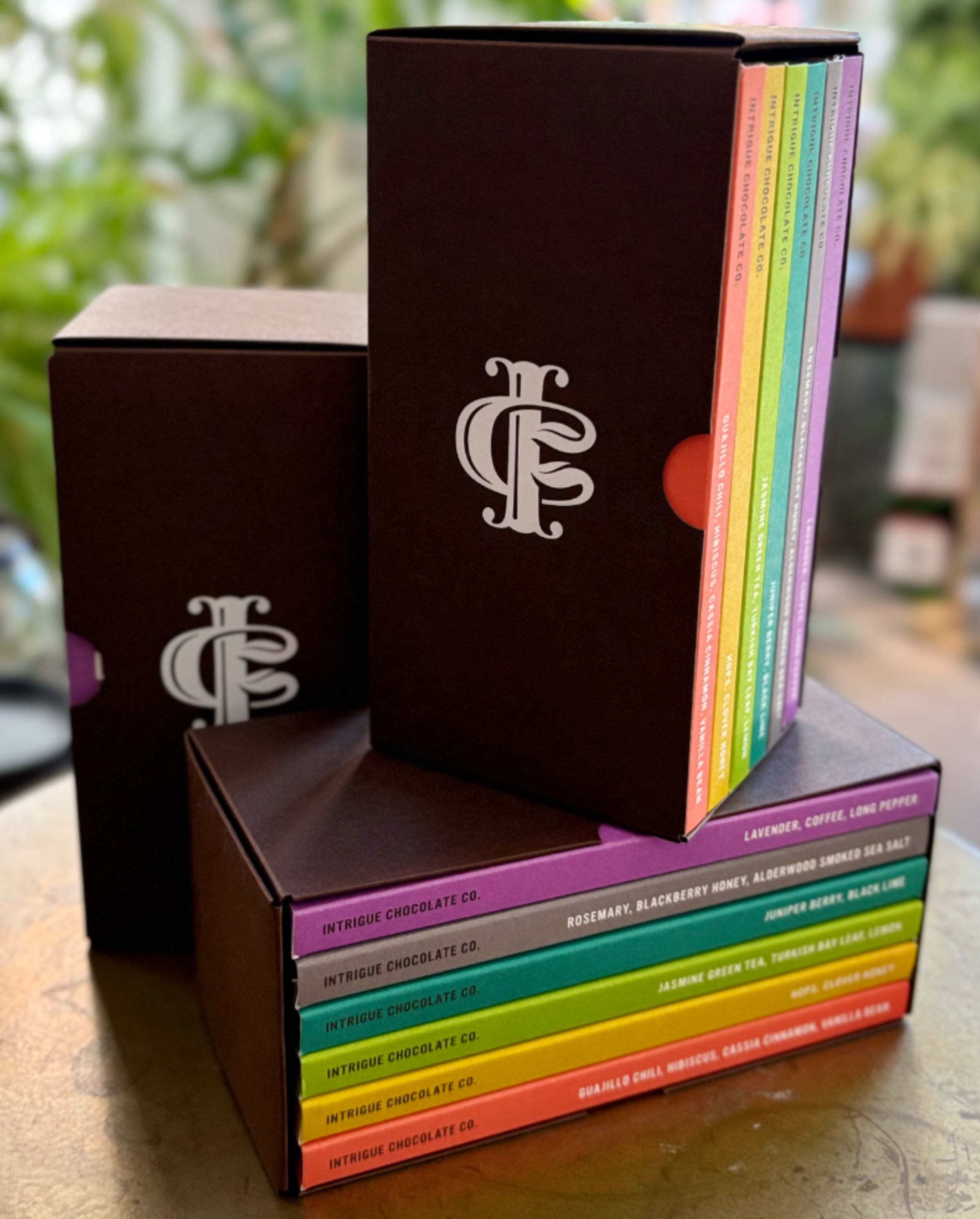 Intrigue Chocolate Co. Little Chocolate Library - This creamy, delectable chocolate melts in your mouth, and takes your tastebuds on a wondrous journey. Each box contains 6 individually wrapped 2.5 ounce chocolate bars in a variety of flavors.   The flavors of each variety box are as follows: Lavender, Coffee &amp; Long Pepper - 64% Dark; Rosemary, Blackberry Honey &amp; Alderwood Smoked Sea Salt - 64% Dark; Juniper Berry &amp; Black Lime - 68% Dark; Jasmine Green Tea, Turkish Bay Leaf &amp; Lemon - 67% Dark; Hops &amp; Clover Honey - 59% Dark; Guajillo Chili, Hibiscus, Cassia Cinnamon &amp; Vanilla Bean - 67% Dark