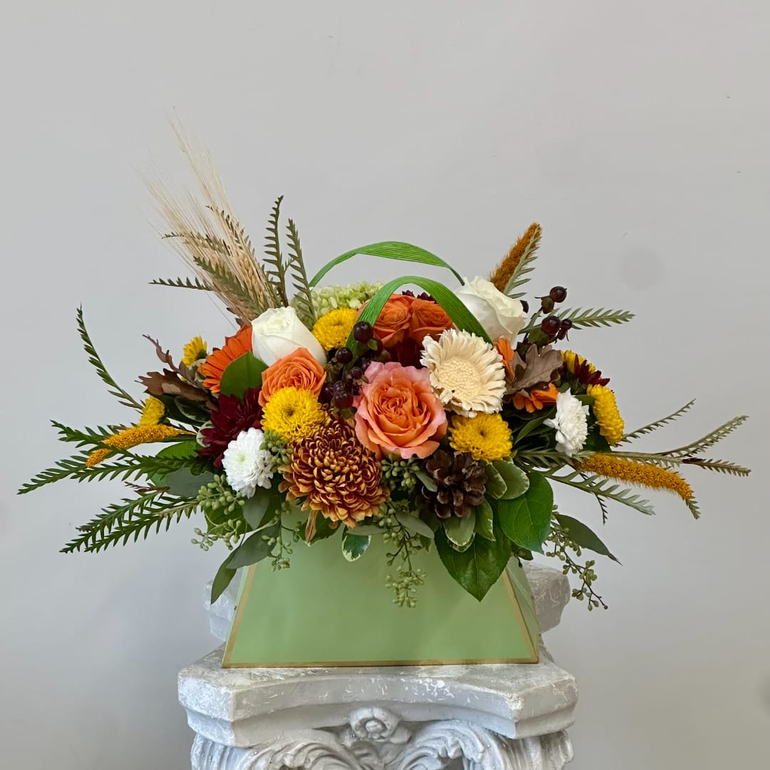 Mixed autumn bouquet in a green box with orange, white, and yellow flowers