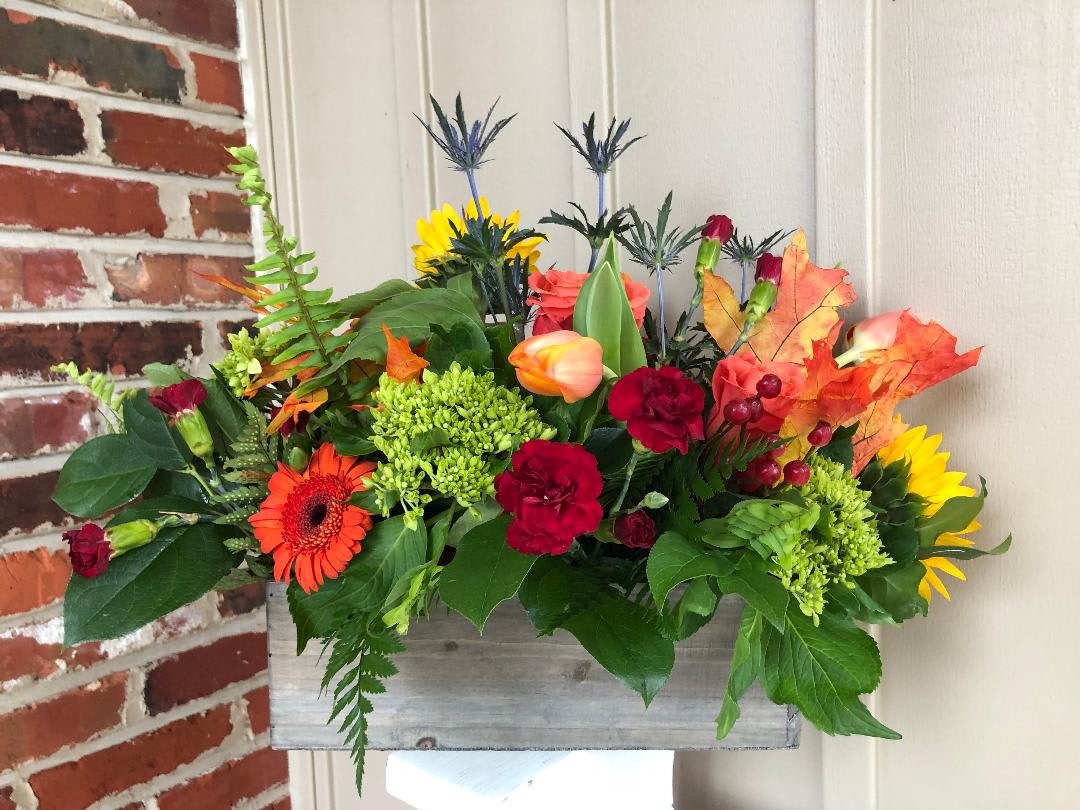 Colorful mixed flower arrangement in a rustic wooden box