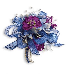 Feel The Beat Corsage - Dance the night away in dark, dramatic blue hydrangea and purple stock.  Blue hydrangea, purple stock and bear grass with rhinestone touches.  Approximately 6" W x 4 1/2" H  Orientation: N/A