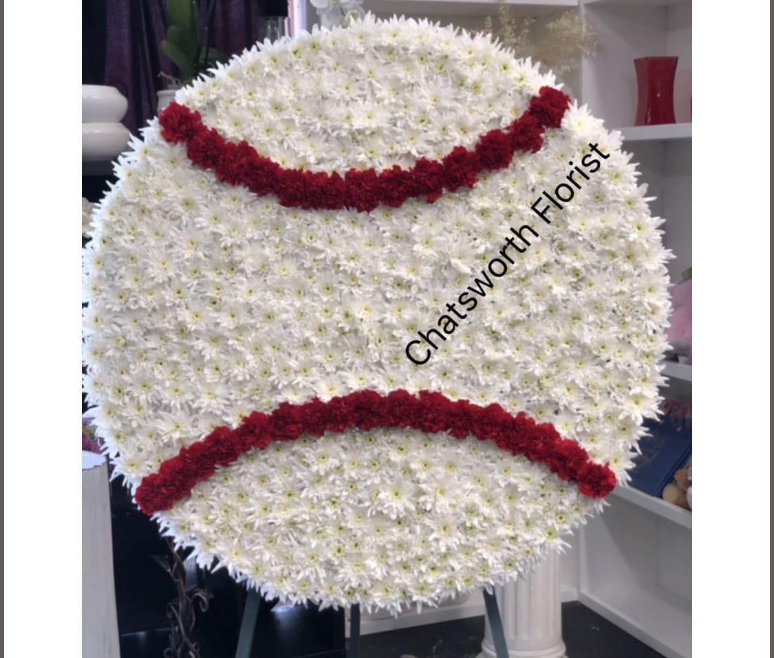 Large round floral tribute shaped like a baseball with red stitching