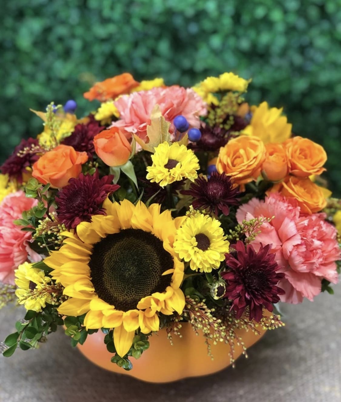 SOMETHIN' PUMPKIN BOUQUET - BRING AUTUMN INSIDE YOUR HOUSE WITH OUR CERAMIC PUMPKIN FILLED WITH FALL FLOWERS AND COLORS. SUNFLOWERS, SPRAY ROSES, ORANGE CARNATIONS, YELLOW AND BURGUNDY POMPOMS, BERRIES, SOLIDASTER AND OUR CERAMIC PUMPKIN VASE.