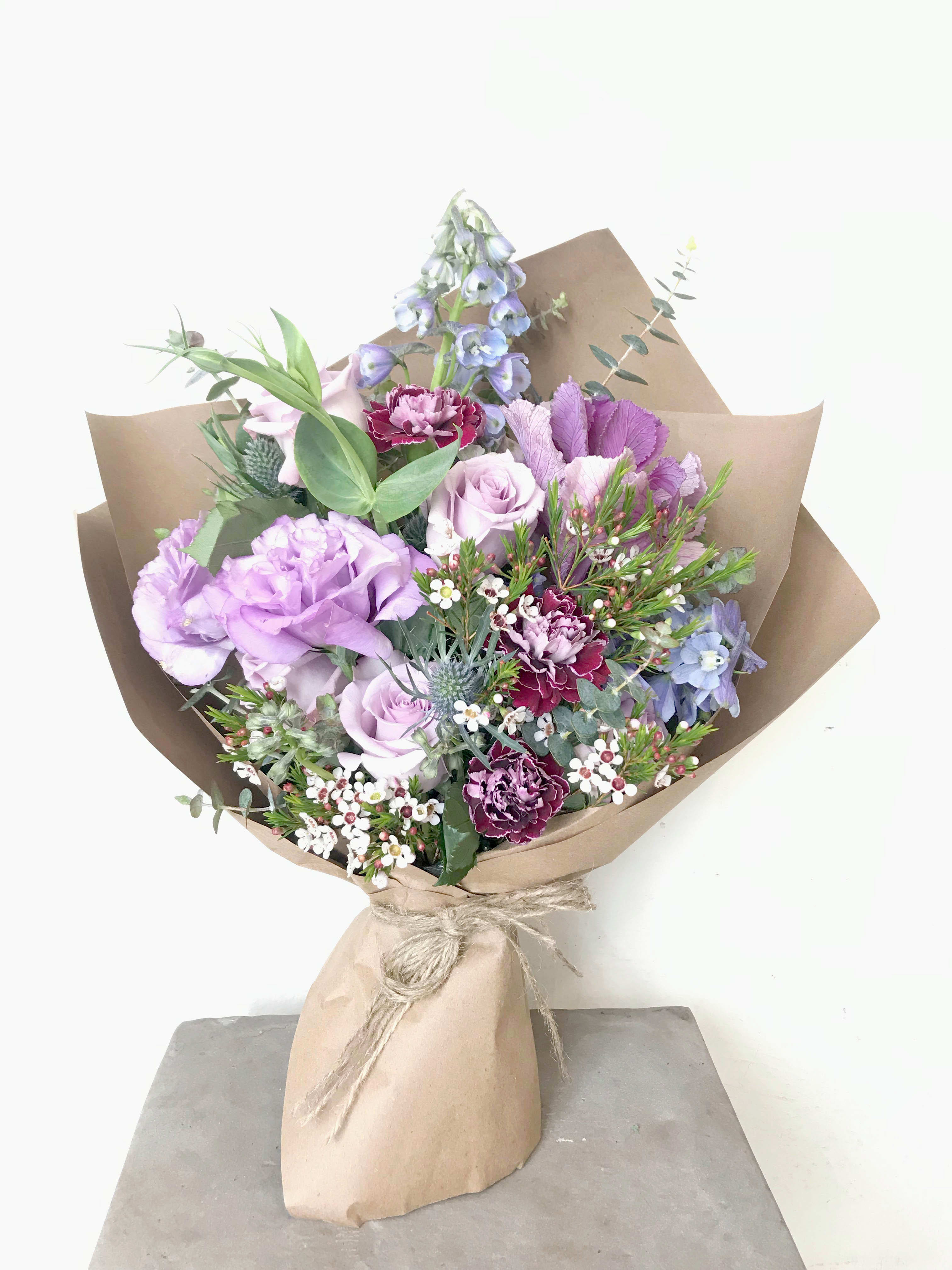 Lavender and pink mixed bouquet wrapped in brown paper