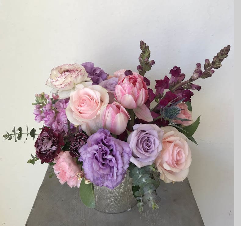 Pink and lavender floral arrangement in a silver vase