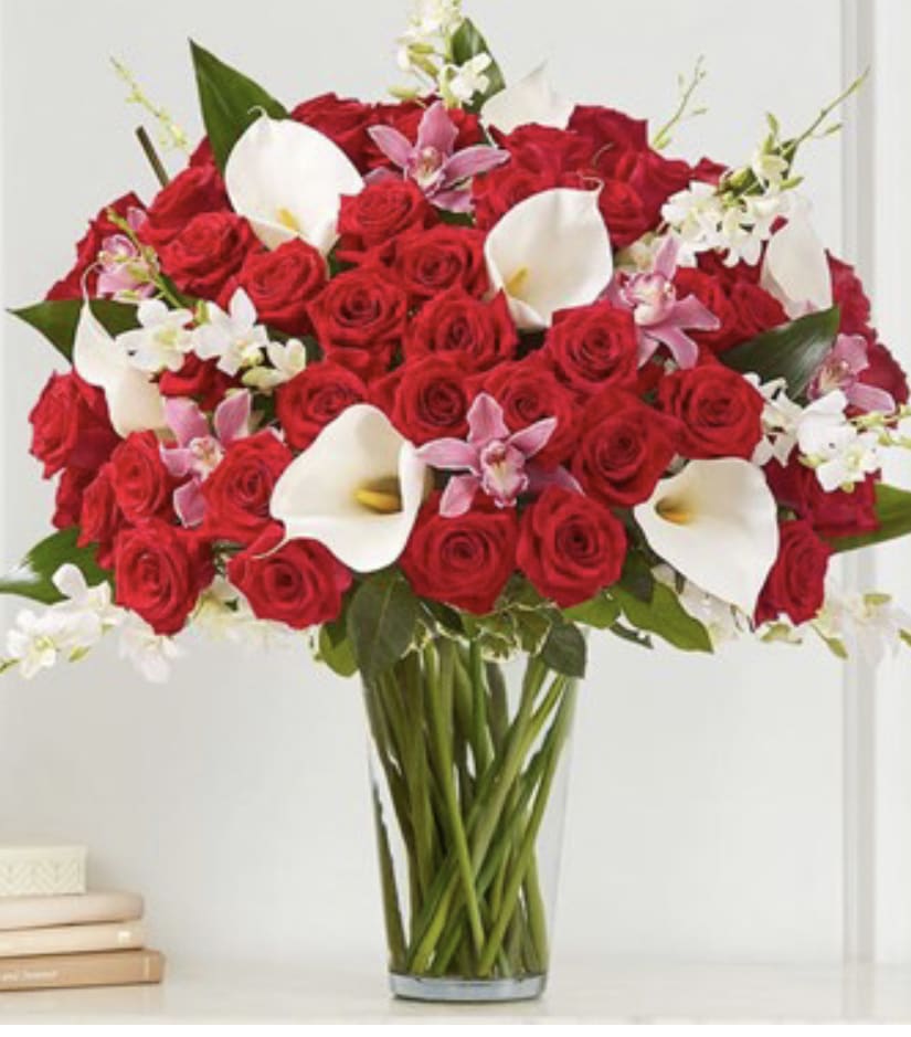 Elegant Extravagance™ Bouquet - The ultimate Valentine’s WOW gift! Our extravagant arrangement towers over two feet tall, featuring a gathering of roses, orchids and calla lilies in striking shades of red, pink and white. Accented by lush and textural greenery, it’s artistically designed in a clear glass vase to let the beauty of each bloom stand out. When it comes to surprising the one you love, this is truly the most unforgettable gift you can send. All-around arrangement with red roses; white calla lilies and Dendrobium orchids; pink cymbidium orchids; accented with aspidistra leaf and assorted greenery Artistically designed in a clear glass vase