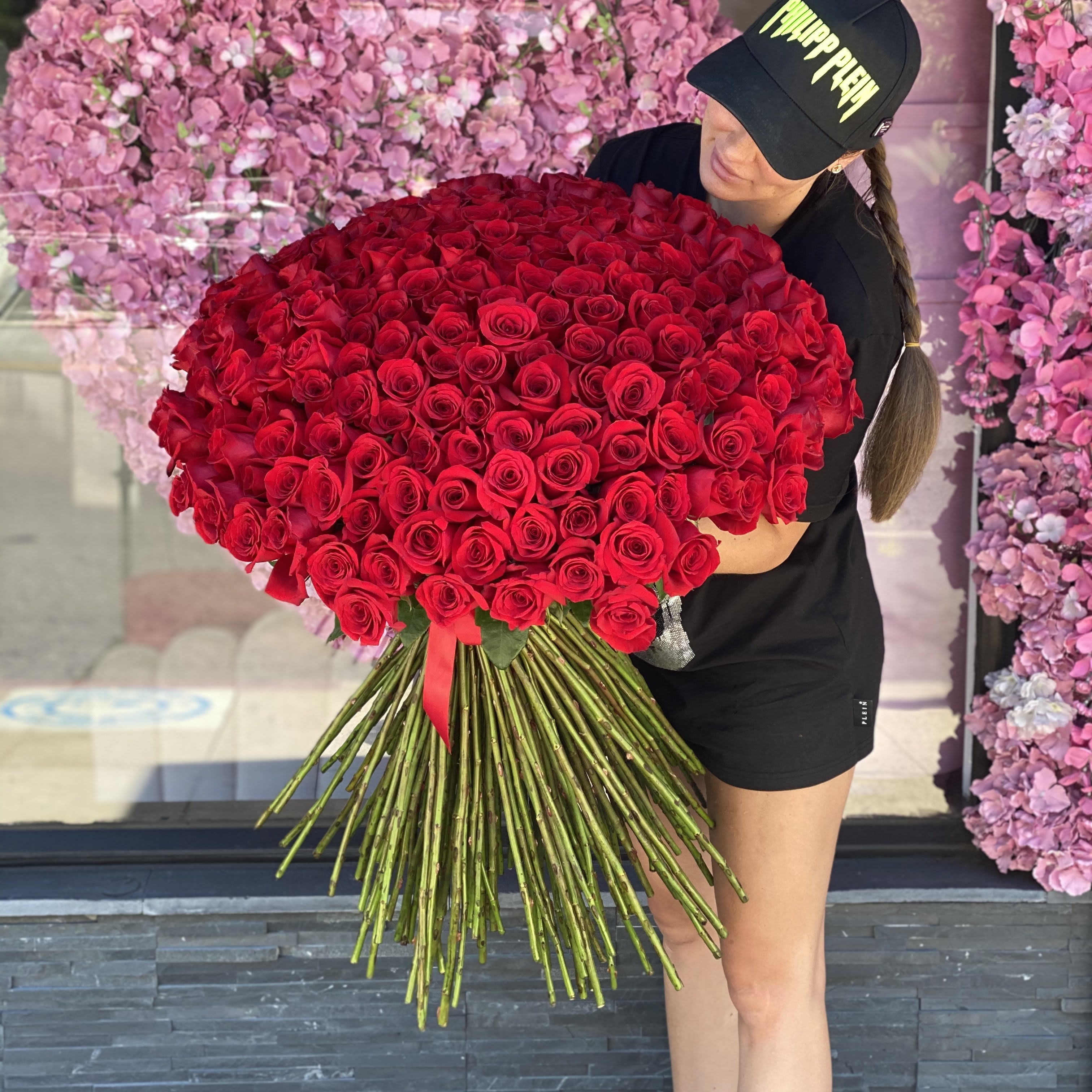 Woman holding a large bouquet of red roses