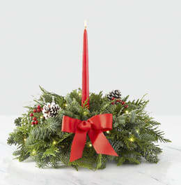Deck the Halls Centerpiece with Lights - "Decking the halls" is one of the best parts of the holidays. Make your dining table look beautifully festive with a centerpiece handcrafted with fresh, fragrant Christmas greens, and accents of red berry clusters and a red bow. Light the red taper candle to create a warm glow as you celebrate the season with friends and family. To make it extra festive, we added a sparkly string of lights to help brighten your holiday.