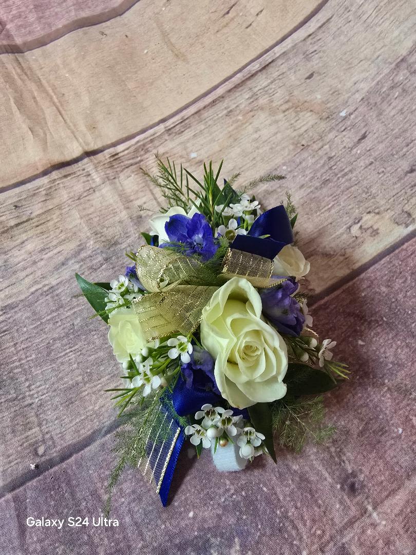 Small bouquet with white roses, blue flowers, and gold ribbon