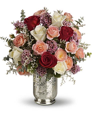 Bouquet of red, white, and peach roses in a silver vase