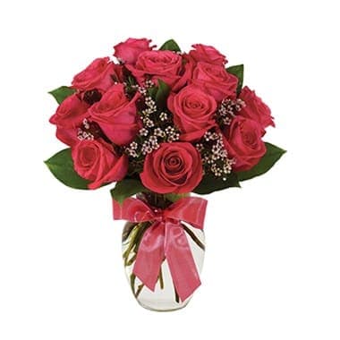 Pink rose bouquet in a clear vase with a ribbon