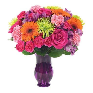 Bright mixed bouquet in a purple glass vase