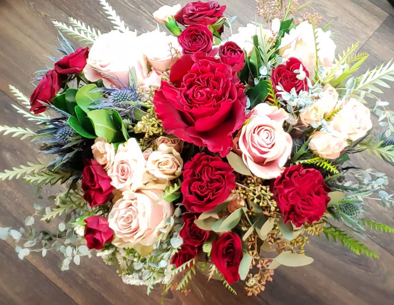 Bouquet of red and blush roses with mixed greenery