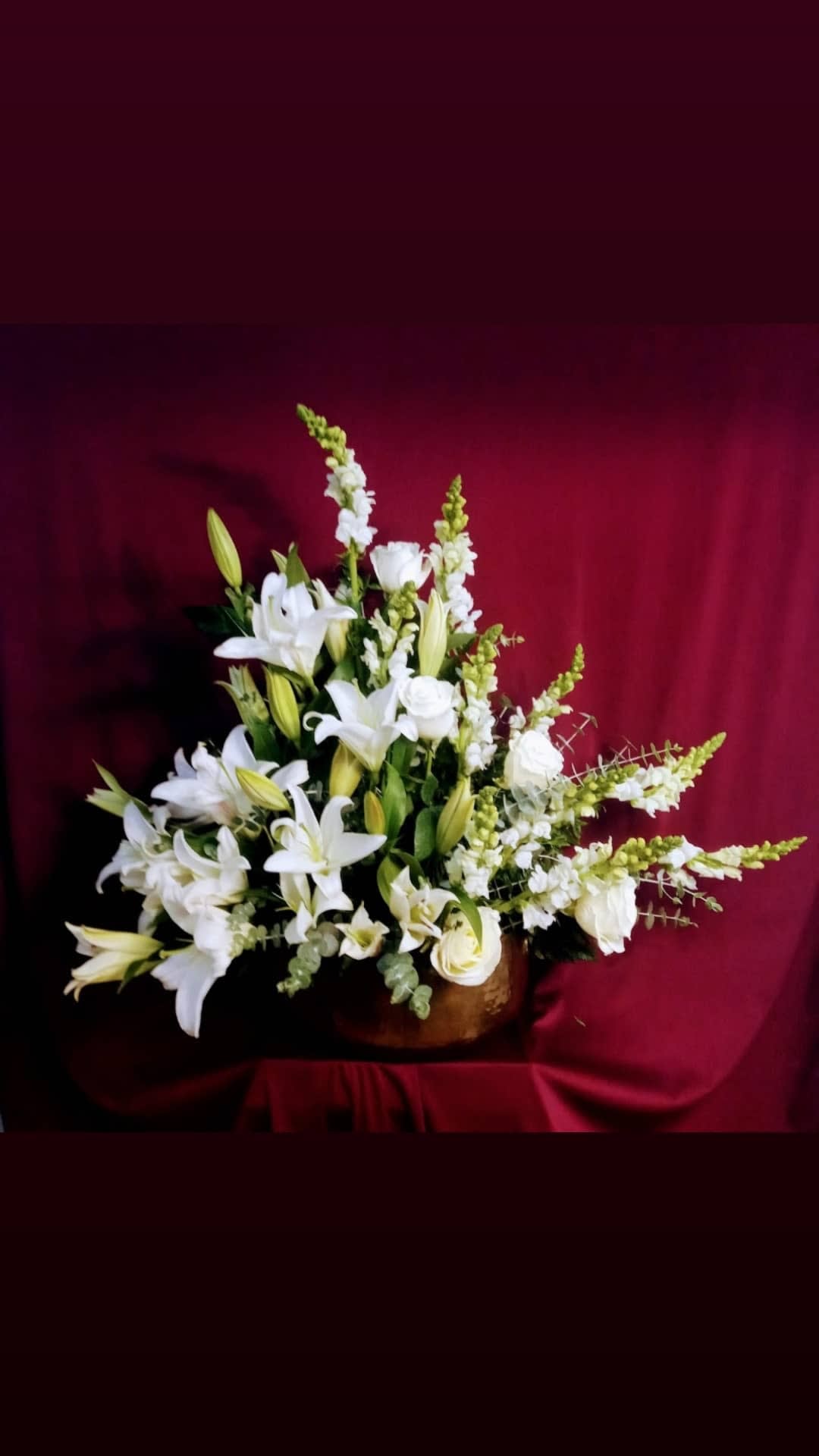 White lilies and roses arranged in a low vase