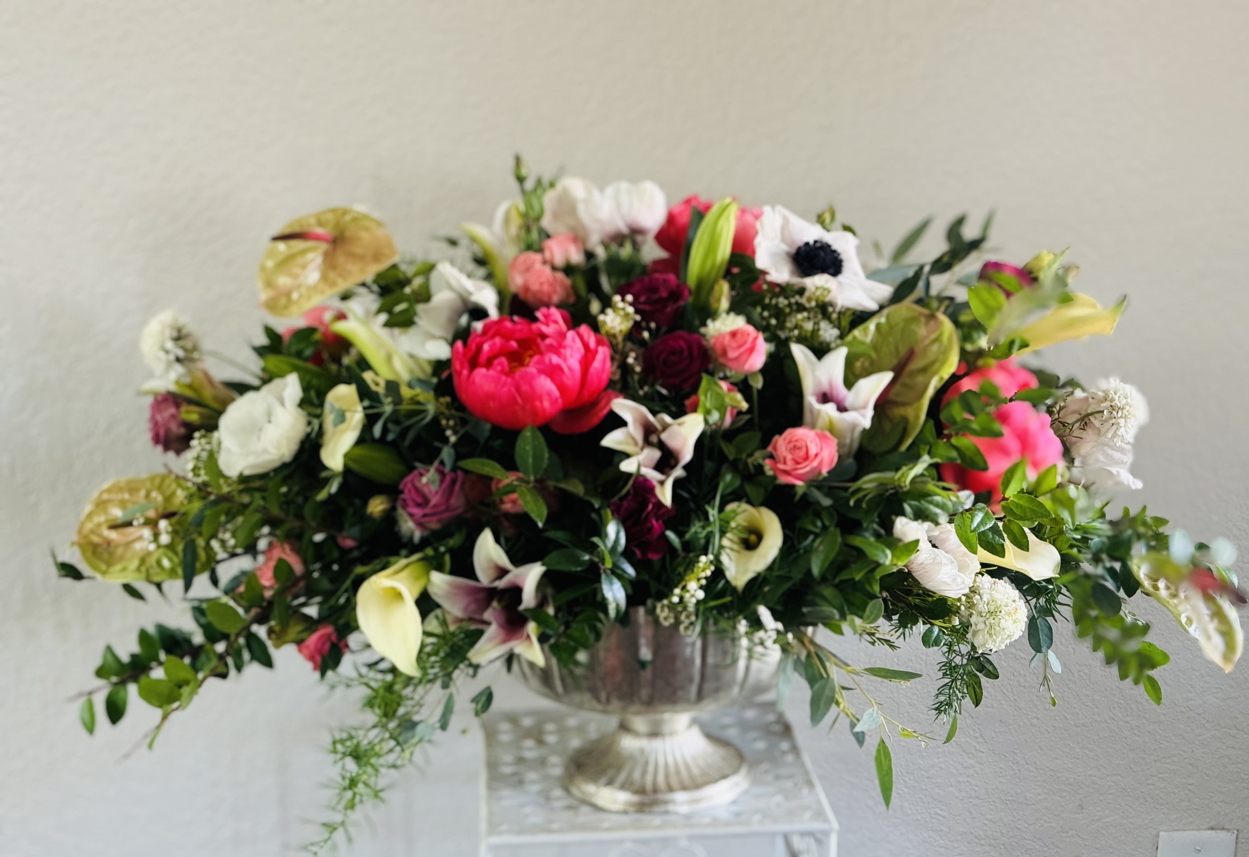 Large mixed floral arrangement in a silver urn vase