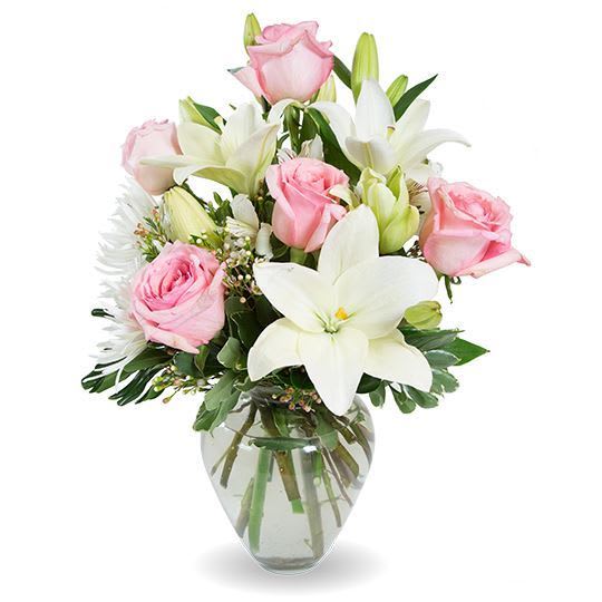 Pink roses and white lilies arranged in a clear glass vase
