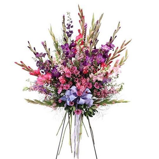 Tall bouquet of pink and purple flowers with a lavender ribbon