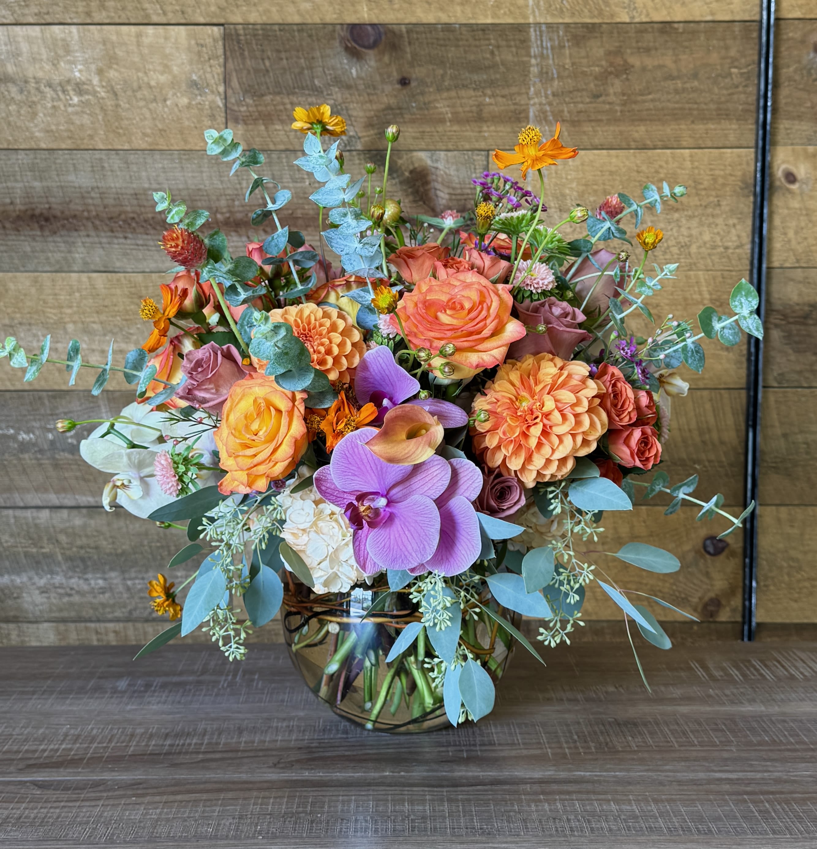 TOUCH OF MAPL - Fishbowl arrangement mixed with seasonal fall florals, including dahlias, orchids, roses, hydrangea, greenery, and more