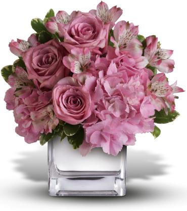 Pink roses and alstroemeria arranged in a clear square vase