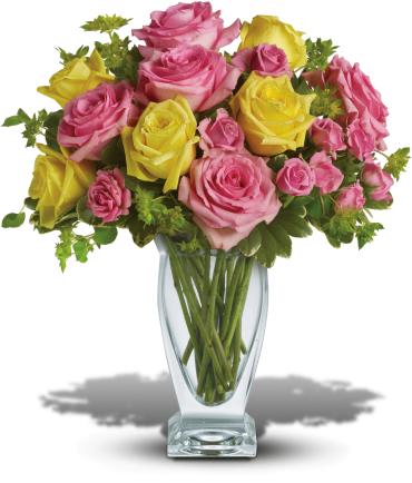 Pink and yellow roses arranged in a clear glass vase