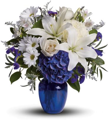 White lilies and daisies with blue hydrangea in a blue vase