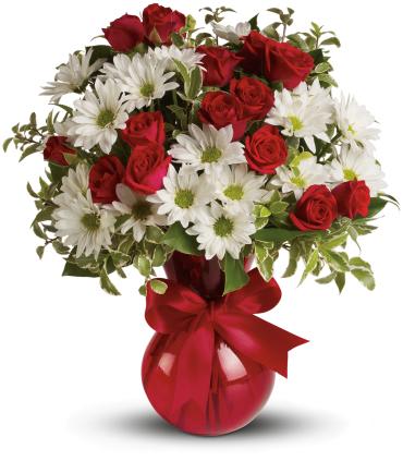 Red roses and white daisies in a red vase with a ribbon