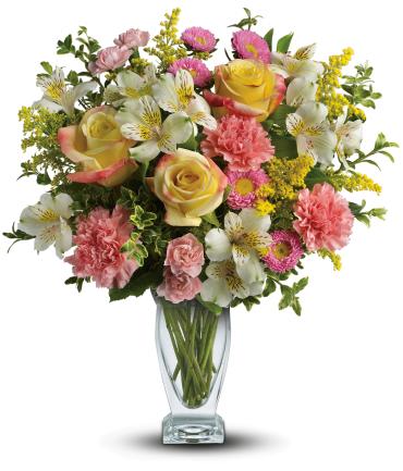 Mixed bouquet of roses, carnations, and white alstroemeria in a glass vase