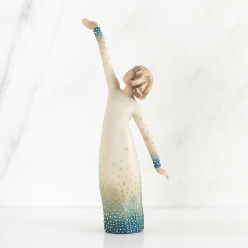 Decorative figurine of a woman in a long dress with one arm raised