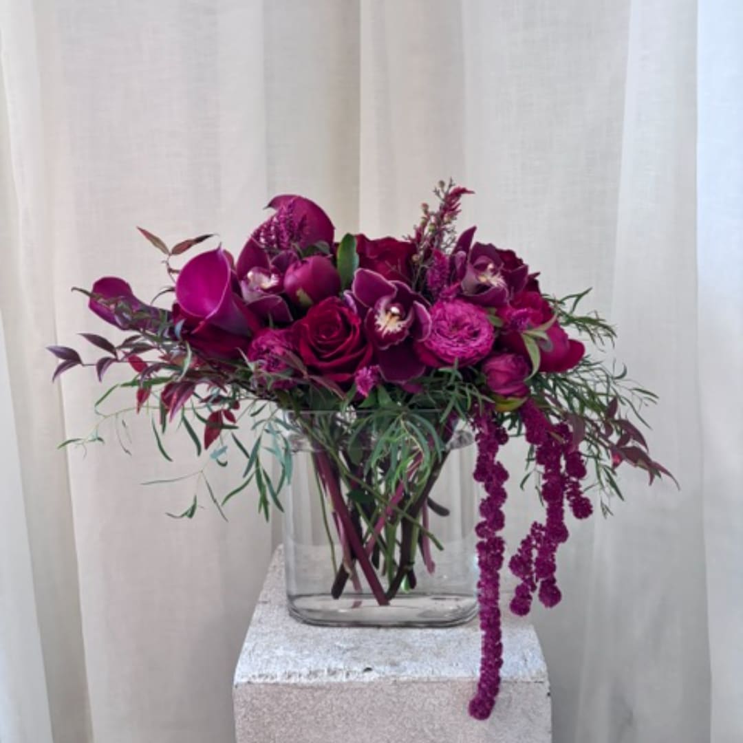 Magenta floral arrangement in a clear glass vase